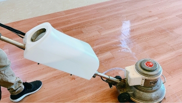 専用器具を使い床面にワックスがけをするようす