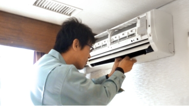 清掃のためエアコンを分解するスタッフ